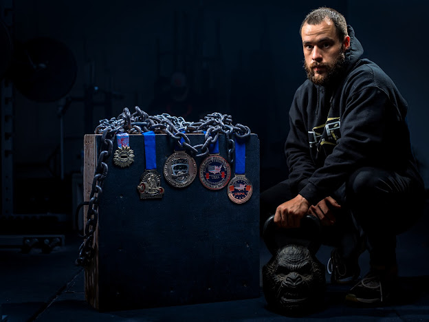 Matt seated next to competition medals